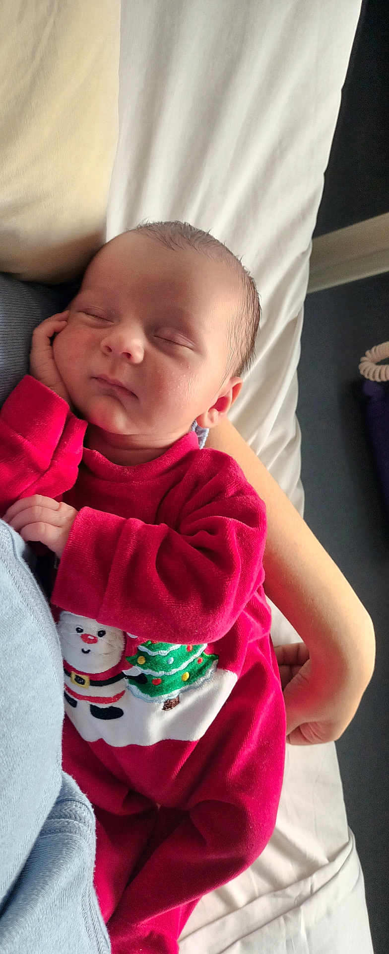 Gabriel participe au concours pour gagner de l'argent avec cette photo : baby, sleeping, infant, red_clothing, christmas_outfit, santa_claus, christmas_tree, hand, arm, bed, blanket, resting, peaceful, cute, portrait, indoors, newborn, soft_light, comfort, cozy