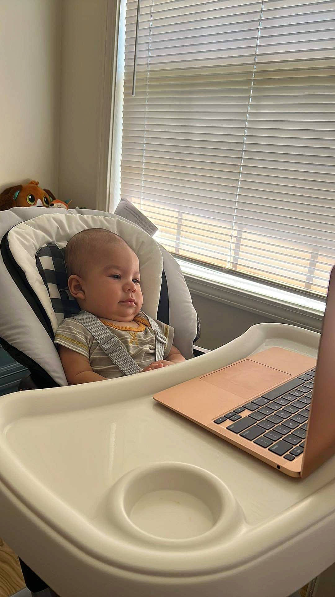 Darwin is registered to the contest to win money with this photo: audio_equipment, baby, baby_toddler_clothing, comfort, computer, desk, gadget, laptop, office_equipment, person, personal_computer, product, room, sitting, table, tableware, toddler, window, window_blind, window_covering