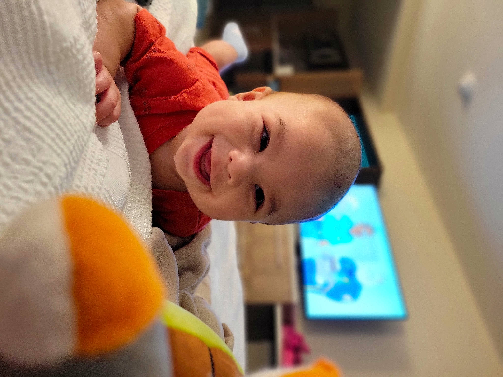Darwin is registered to the contest to win money with this photo: baby, baby_laughing, baby_products, baby_toddler_clothing, cheek, child, comfort, eyebrow, facial_expression, fun, happy, joy, laugh, mouth, nose, orange, person, room, smile, t_shirt