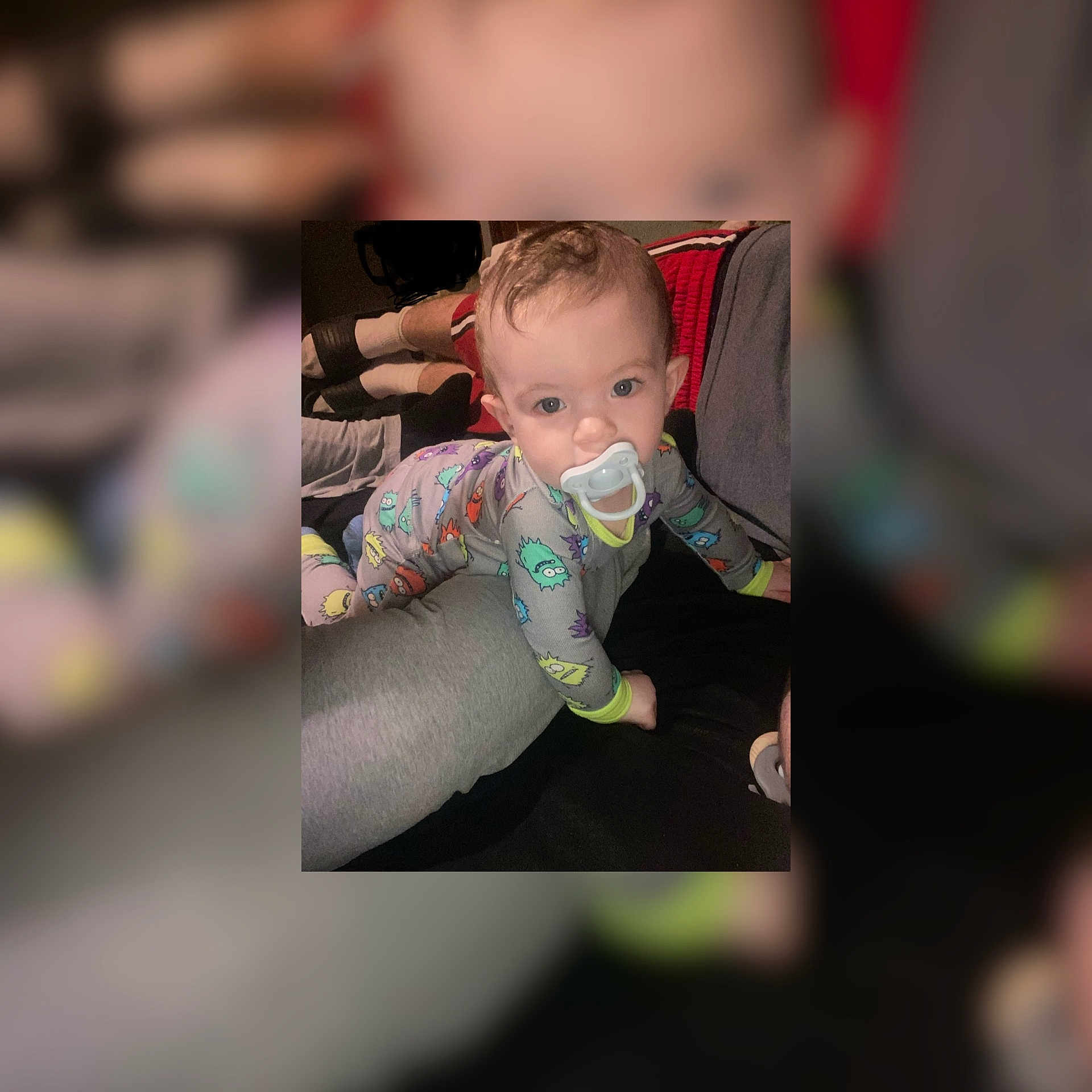 Colby is registered to the contest to win money with this photo: adult, baby, child, clothing, colorful, comfort, couch, cute, face, home, indoor, infant, legs, looking, pacifier, pajamas, person, portrait, relaxation, sitting