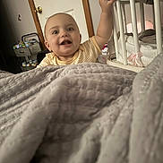 Journiee is registered to the contest to win money with this photo: baby, bedroom, blanket, candid, child, clothing, door, furniture, happy, home, household, indoor, infant, nursery, person, reaching, smiling, soft, wood, young_child