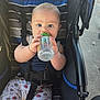 Jhosua joined the competition — help win amazing prizes! baby, infant, child, stroller, baby_bottle, drinking, harness, seat_strap, blue_eyes, blonde_hair, curious_expression, chubby_cheeks, patterned_pants, baseball_pattern, outdoor, sunlight, close_up, portrait, hands, sitting