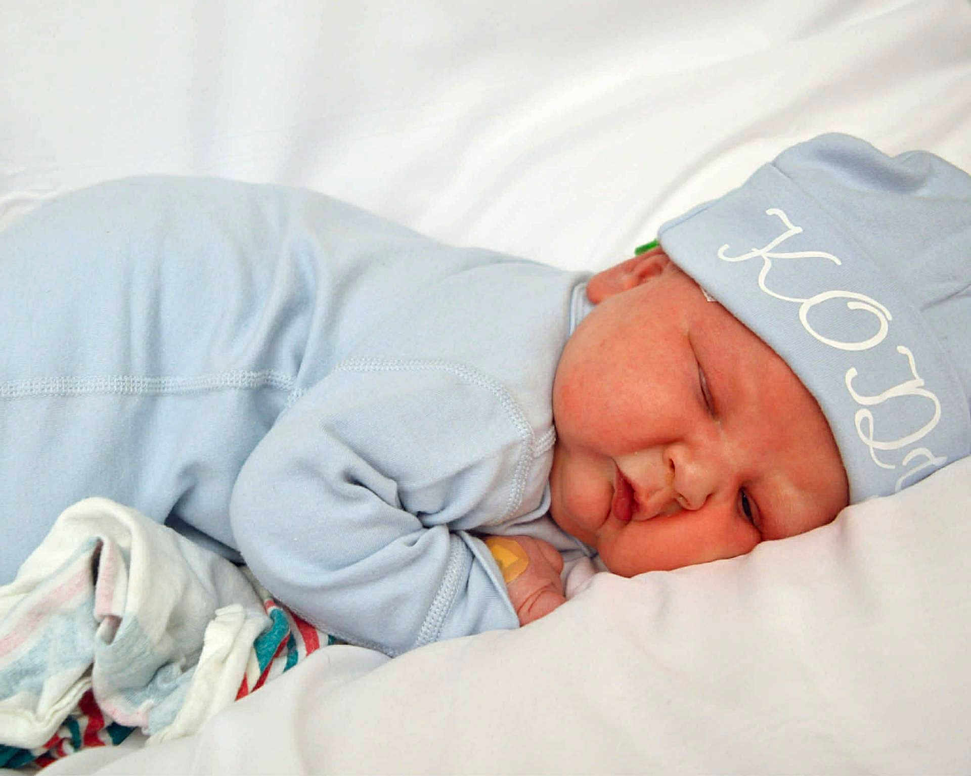 Kody is registered to the contest to win money with this photo: baby, bed, blanket, blue_pajamas, child, comfort, cozy, cute, face, hat, indoors, infant, lying_down, newborn, peaceful, resting, skin, sleeping, soft, toddler