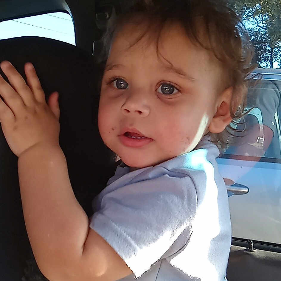 Kyron is registered to the contest to win money with this photo: accessories, baby, belt, bodypart, car, clothing, cushion, face, finger, hand, happy, head, homedecor, person, photography, portrait, smile, t_shirt, transportation, vehicle