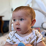 Maëlan a rejoint le concours — aidez-le/la à gagner de superbes lots ! baby, blue_brush, child, chubby_cheeks, closeup, curious, cute, expression, face, hands, holding, human, indoor, infant, onesie, person, portrait, soft_light, tiger_print, young