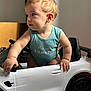 Maëlan a rejoint le concours — aidez-le/la à gagner de superbes lots ! baby, blond_hair, child, curious, cute, expression, face, hand, indoor, infant, light, onesie, person, play, side_view, small_car, soft_light, toy_car, vehicle, wheel