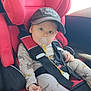 baby, blue_eyes, cap, car_interior, car_seat, child, clothing, cute, dinosaur_pajamas, indoors, infant, pacifier, person, red_car_seat, resting, safety_harness, seat, seat_belt, window, young_child