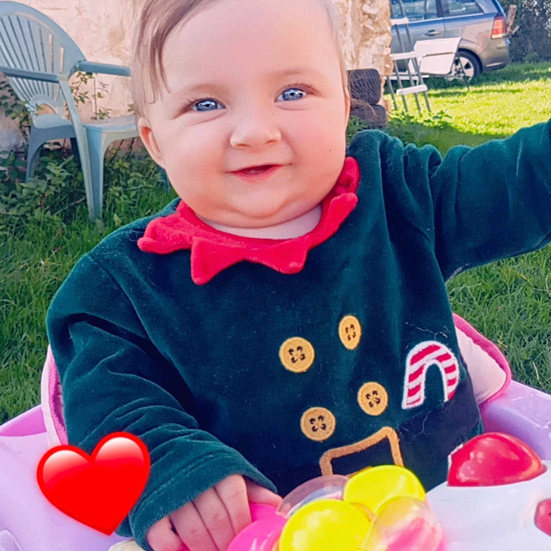 Lylyana participe au concours pour gagner de l'argent avec cette photo : baby, blue_eyes, button_details, child, closeup, daylight, festive_clothing, grass, green_chair, happy, outdoor, person, pink, play, red_heart, smiling, stone_wall, sunny, toy, walker