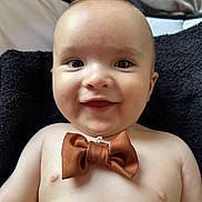 Ewën a rejoint le concours — aidez-le/la à gagner de superbes lots ! baby, child, smiling, bow_tie, shirtless, face, portrait, happy, infant, lying_down, blanket, skin, closeup, cute, young, indoors, expression, head, eyes, mouth