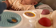 Ewën a rejoint le concours — aidez-le/la à gagner de superbes lots ! baby, drool, toy, activity_center, curious, child, indoor, soft_focus, face, expression, seat, clothing, person, play, colorful, infant, closeup, head, young, looking_up