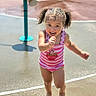 Tanylah is registered to the contest to win money with this photo: child, toddler, swimsuit, pink, curly_hair, pigtails, water_play_area, running, smiling, outdoor, sunny, playground, water_splash, happy, summer, barefoot, fish_shaped_water_feature, striped_clothing, person, fun