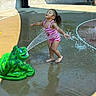 Tanylah is registered to the contest to win money with this photo: child, girl, playground, water_spray, splash_pad, frogsculpture, pink_swimsuit, barefoot, outdoor, summer, fun, water, wet_surface, joyful, play, recreation, sunlight, concrete, park, happy
