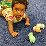 animal_toy, baby, blue_carpet, carpet, child, colorful_clothing, crawling, curious, cute, expression, face, floor, hand, happy, indoor, infant, onesie, playtime, toy, young_child
