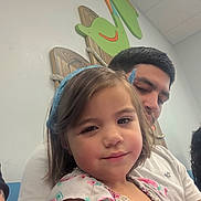 Rosabella joined the competition — help win amazing prizes! child, girl, man, headband, floral_dress, indoor, wall_decoration, wooden_art, smile, family, portrait, people, casual_clothing, short_hair, beard, seated, playful, colorful, close_up, happy