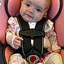 baby, car_seat, child, closeup, clothing, comfort, cute, drool, flamingo_pattern, head_support, indoor, infant, onesie, pacifier, person, pink, seat_belt, smile, straps, young_child
