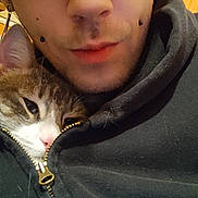 Eri a rejoint le concours — aidez-le/la à gagner de superbes lots ! person, cat, face, closeup, hoodie, zipper, piercing, indoor, snuggling, pet, animal, young_adult, cozy, casual_clothing, brown_hair, eyebrows, skin, expression, looking_at_camera, cute