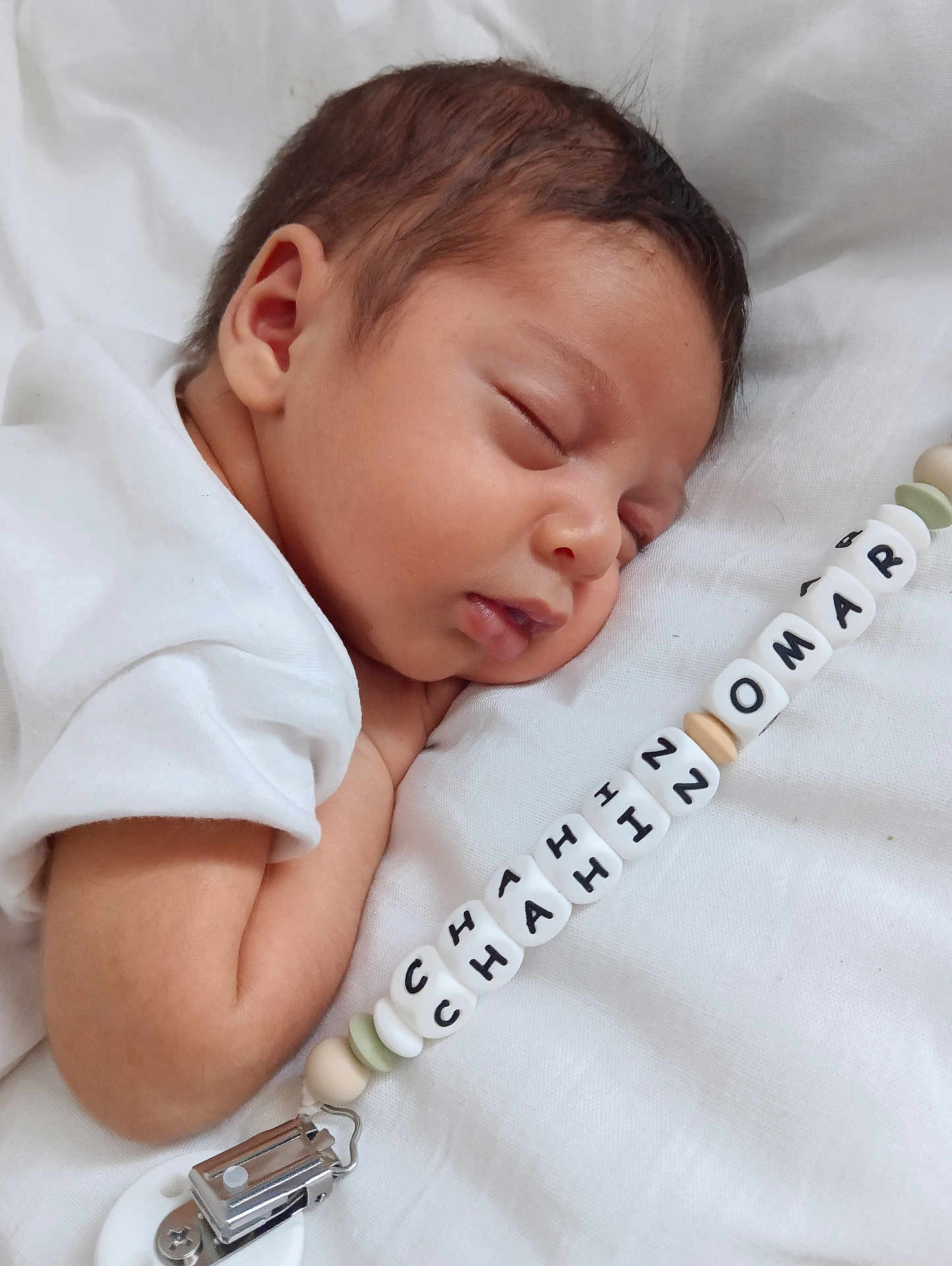 Chairi Chahinomar a rejoint le concours — aidez-le/la à gagner de superbes lots ! baby, sleeping, pacifier_clip, white_clothing, infant, closeup, face, skin, peaceful, rest, soft_lighting, cute, child, newborn, hand, fabric, portrait, indoors, calm, personalized