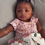 Mayci joined the competition — help win amazing prizes! baby, child, infant, girl, face, portrait, couch, blanket, floral, pigtails, earrings, clothing, soft, comfort, indoor, cute, expression, skin, person, relaxing