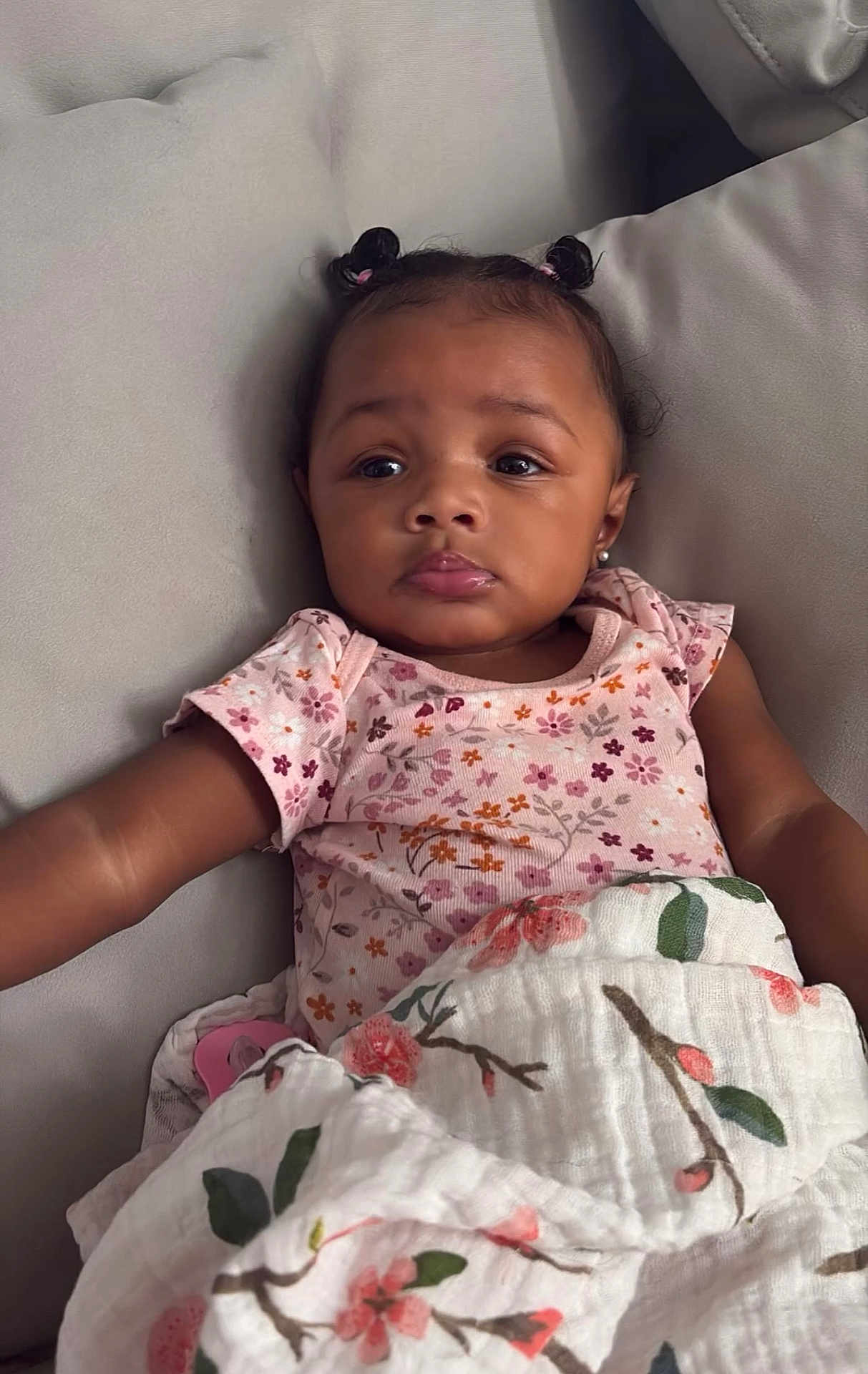 Mayci joined the competition — help win amazing prizes! baby, child, infant, girl, face, portrait, couch, blanket, floral, pigtails, earrings, clothing, soft, comfort, indoor, cute, expression, skin, person, relaxing