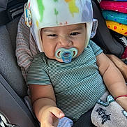Alonzo joined the competition — help win amazing prizes! baby, infant, child, helmet, pacifier, car_seat, vehicle, sitting, portrait, face, hair, smiling, striped_shirt, blanket, colorful,  안전, indoors, close_up, infant_safety, travel