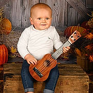 Camille participe au concours pour gagner de l'argent avec cette photo : baby, ukulele, barefoot, wooden_crate, pumpkin, autumn, fall_leaves, rustic, smiling, child, jeans, white_shirt, indoors, portrait, musical_instrument, cute, seasonal, cozy, decor, happy
