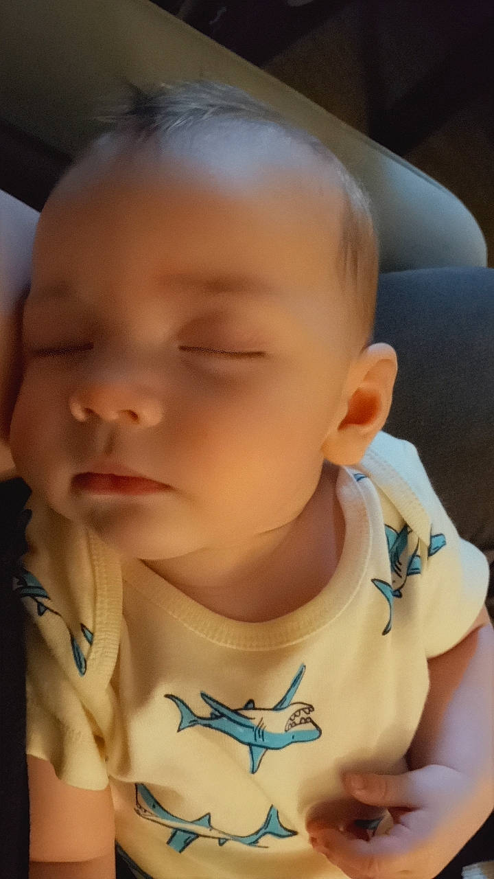 Kevin is registered to the contest to win money with this photo: applique, baby, bodypart, clothing, couch, ear, face, finger, frown, furniture, hand, head, homedecor, newborn, pattern, person, photography, portrait, sad, t_shirt