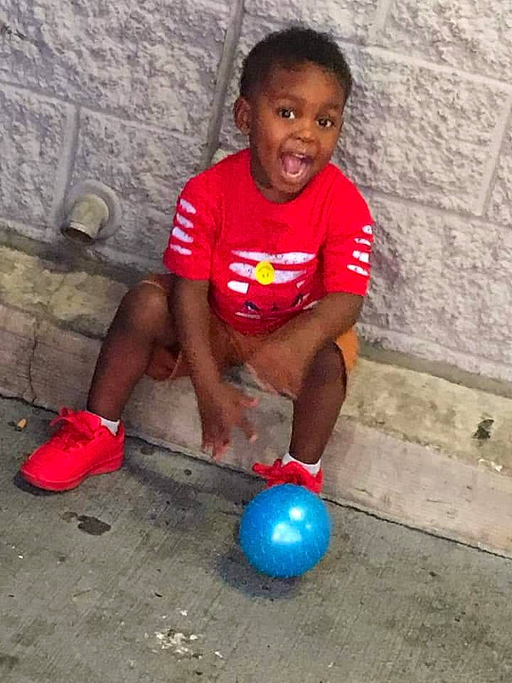 David is registered to the contest to win money with this photo: child, concrete, electric_blue, event, foot, fun, happy, human_leg, leisure, people, person, photograph, play, shorts, sitting, smile, soil, t_shirt, toddler, vacation