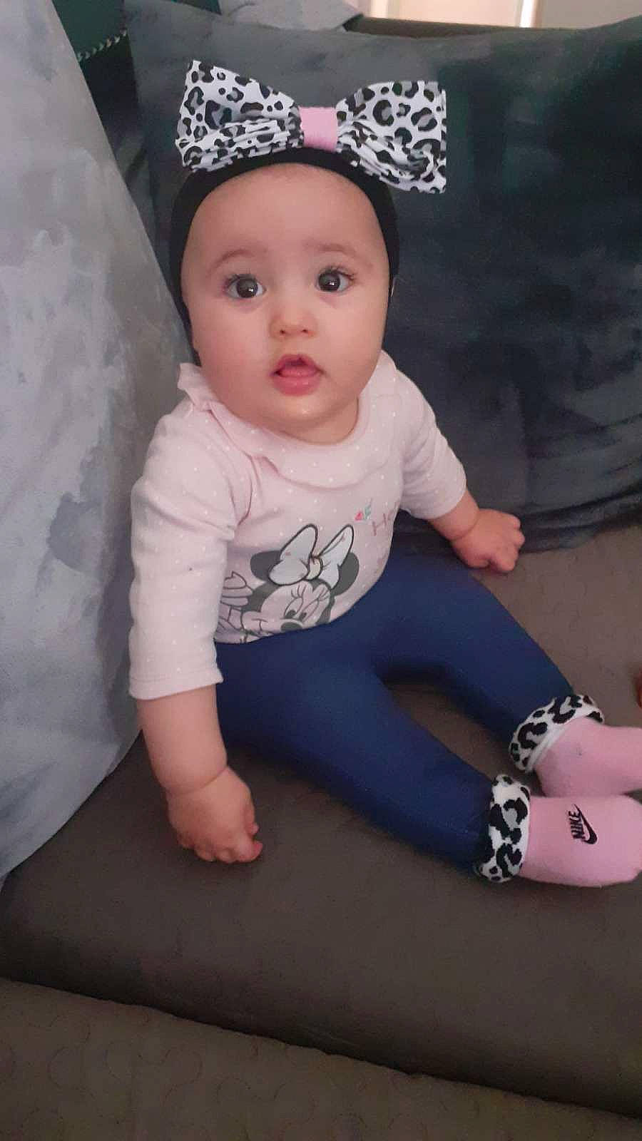 Leïna participe au concours pour gagner de l'argent avec cette photo : baby, baby_toddler_clothing, black, cap, child, clothing, costume_hat, fashion_accessory, finger, hair_accessory, head, headwear, human_leg, knee, pattern, person, pink, shorts, sleeve, t_shirt