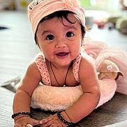 Fiyana joined the competition — help win amazing prizes! baby, child, smile, headband, pink, cushion, floor, indoors, cute, face, hands, knitted, jewelry, bracelets, portrait, happy, toddler, person, bright, soft