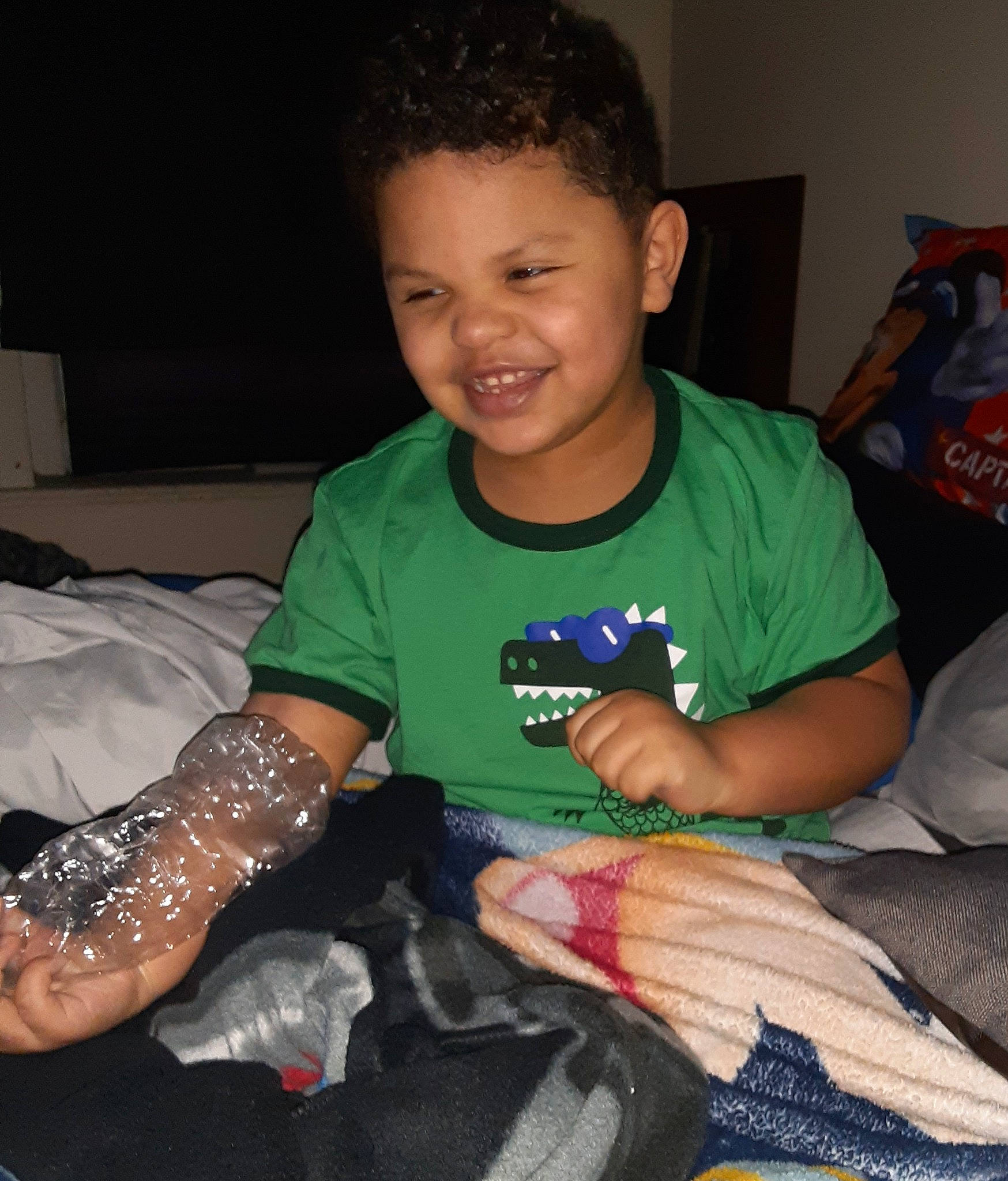 Malachai is registered to the contest to win money with this photo: arm, child, elbow, finger, hand, joy, leg, person, play, sitting, smile, t_shirt, toddler