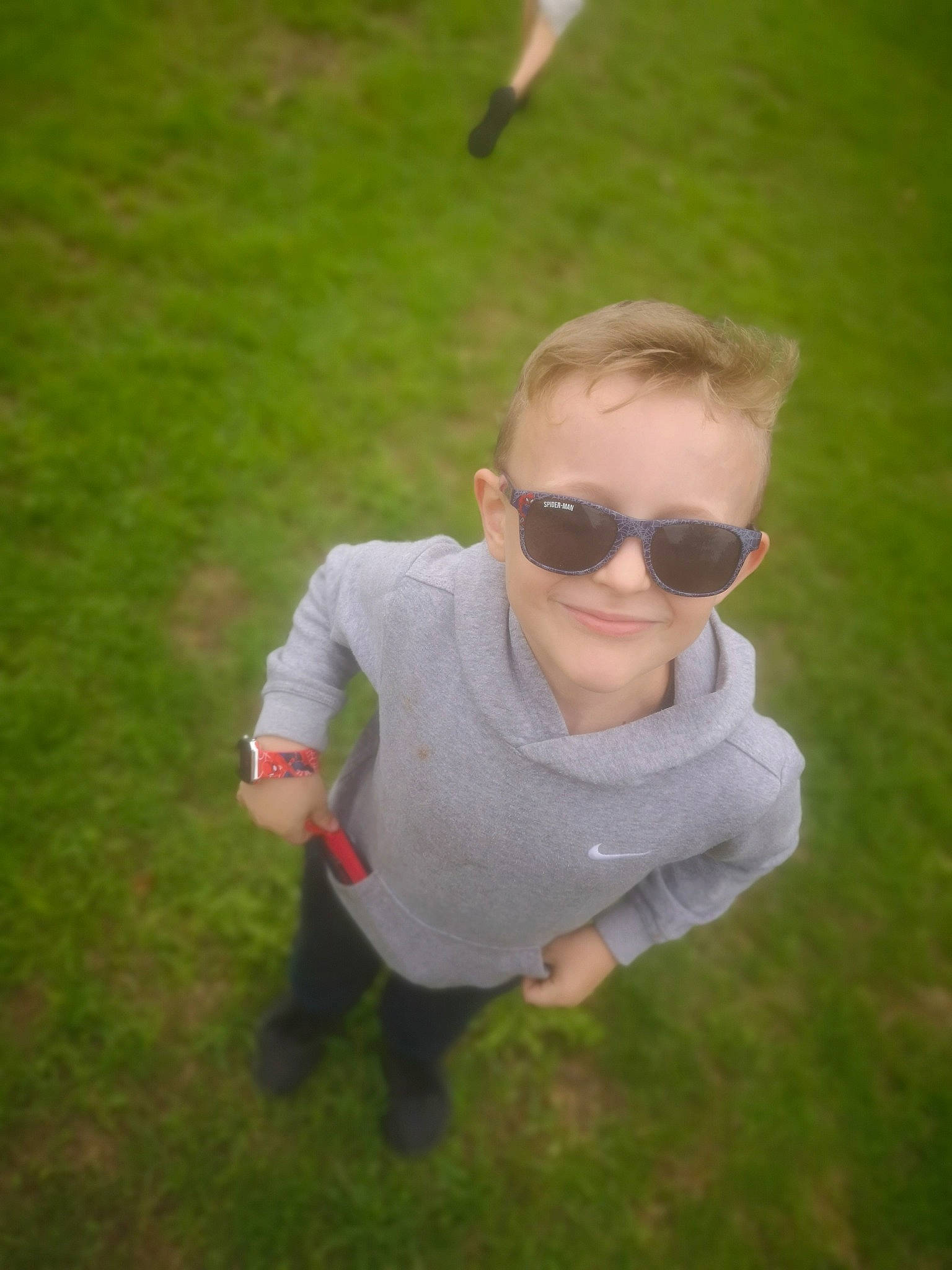Harrison Charles is registered to the contest to win money with this photo: baby_toddler_clothing, eyewear, fun, glasses, goggles, grass, grassland, hair, happy, joy, lawn, leisure, person, personal_protective_equipment, plant, recreation, sitting, sleeve, smile, sunglasses
