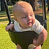 Azalea is registered to the contest to win money with this photo: baby, child, swing, outdoor, park, grass, sunlight, trees, blue_eyes, blond_hair, infant, playground, seat, summer, daylight, curious, holding, cute, person, nature