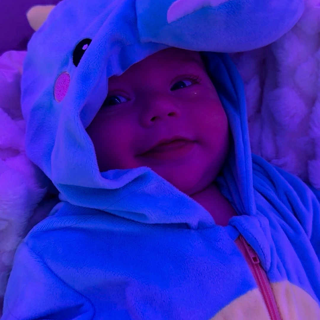 Koltyn joined the competition — help win amazing prizes! baby, dinosaur_costume, blue, hoodie, smile, infant, onesie, child, purple_light, cute, soft_texture, blanket, cozy, portrait, indoor, happy, baby_hand, face, apparel, sleepwear