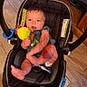 Koltyn is registered to the contest to win money with this photo: baby, car_seat, child, toy, indoor, flooring, happy, smiling, face, plush_toy, denim_overalls, foot, hand, infant, person, seat_belt, wooden_furniture, blue_eyes, skin, clothing