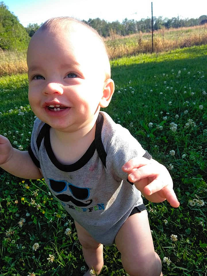 Atreyu is registered to the contest to win money with this photo: baby, child, facial_expression, finger, grass, grass_family, hand, happy, lawn, leaf, meadow, person, plant, play, smile, summer, thumb, toddler, tooth