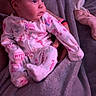 baby, infant, pajamas, blanket, hand, person, sleepwear, indoor, portrait, cozy, child, soft_light, purple_light, curious, seated, clothing, young_child, couch, warm, holding