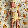 Lorelai is registered to the contest to win money with this photo: baby, infant, smiling, yellow_clothing, onesie, hat, blanket, winnie_the_pooh, cartoon_characters, floor, wooden_floor, cute, lying_down, baby_boy, baby_girl, child, adorable, two_months, soft_texture, home