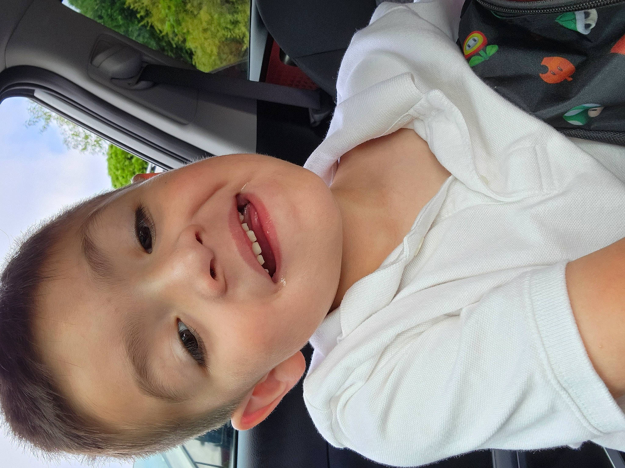 Ian is registered to the contest to win money with this photo: baby, cheek, child, eye, eyelash, eyewear, finger, fun, gesture, happy, lip, mouth, nose, person, plant, skin, smile, toddler, tree, vehicle_door