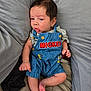 baby, infant, child, overalls, clothing, mickey_mouse, blue, cushions, gray, soft, pout, cute, sleepwear, foot, hand, portrait, indoors, comfort, resting, young