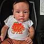 baby, infant, child, car_seat, clothing, shirt, shorts, face, person, sitting, drool, cute, young, indoors, black_background, expressionless, head, skin, eyes, hands