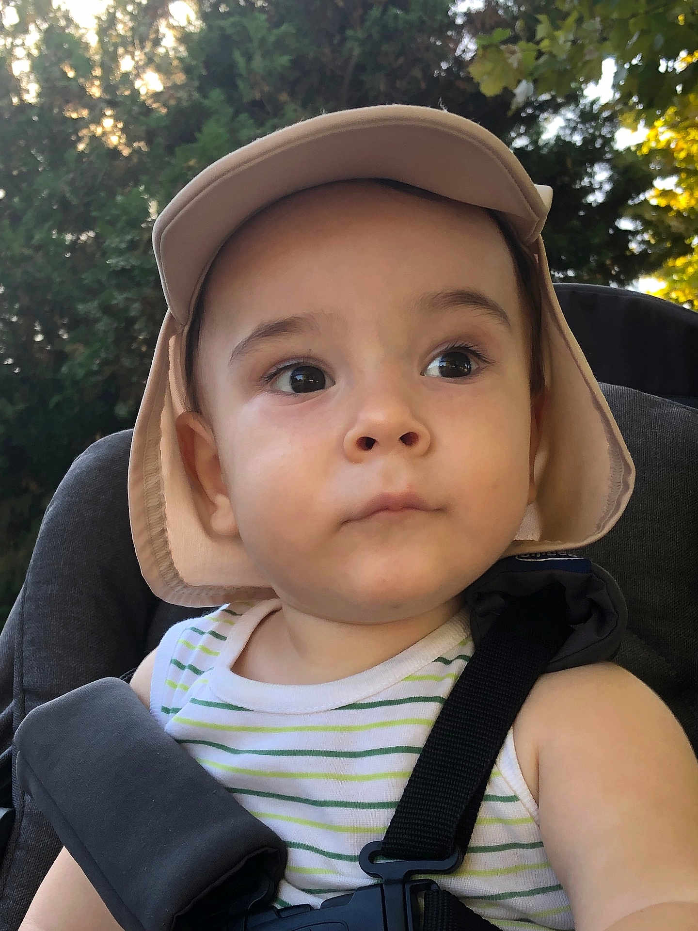Alessio a rejoint le concours — aidez-le/la à gagner de superbes lots ! child, toddler, hat, striped_clothing, car_seat, seatbelt, outdoor, greenery, sunlight, portrait, face, eyes, expression, summer, baby, nature, daylight, closeup, young_child, candid