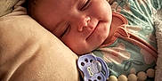 Delilah is registered to the contest to win money with this photo: baby, infant, sleeping, pacifier, pillow, blanket, onesie, smile, face, close_up, cozy, bedtime, bedding, pacifier_clip, bead_teether, chubby_cheeks, snuggling, indoor, portrait, calm