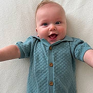 Aaron is registered to the contest to win money with this photo: baby, smiling, blue_romper, infant, happy, lying_down, arms_outstretched, cute, child, portrait, soft_texture, white_background, buttoned_clothing, face, head, skin, eyes, mouth, joyful, young