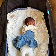 Sophia is registered to the contest to win money with this photo: baby, infant, child, dress, denim, blanket, bassinet, pacifier, white_leggings, mesh, soft_texture, indoor, sleeping_area, cute_clothing, newborn, resting, baby_girl, fabric, comfort, cozy