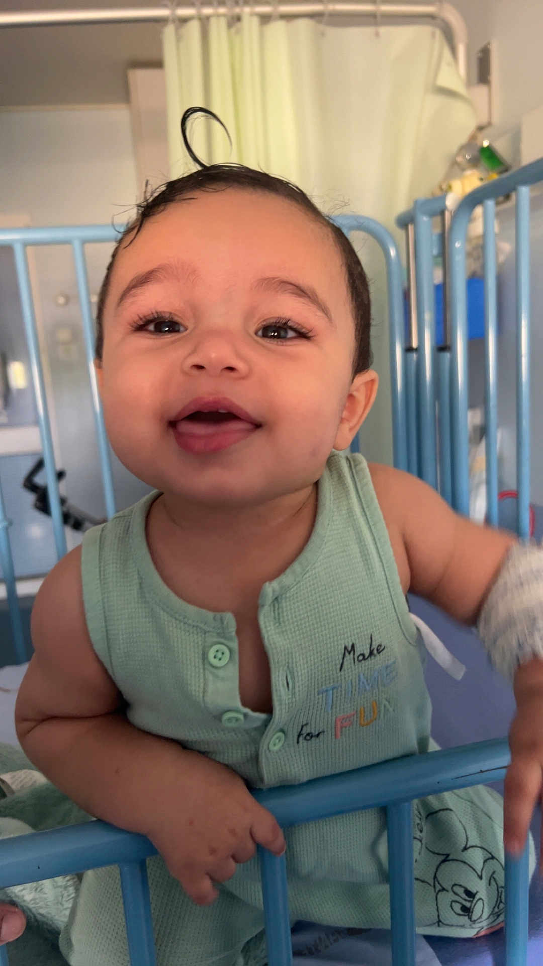 Amine participe au concours pour gagner de l'argent avec cette photo : toddler, child, smiling, baby, crib, hospital, green_clothing, curly_hair, indoor, close_up, happy, portrait, baby_wear, hand, bed, furniture, cute, infant, playful, person