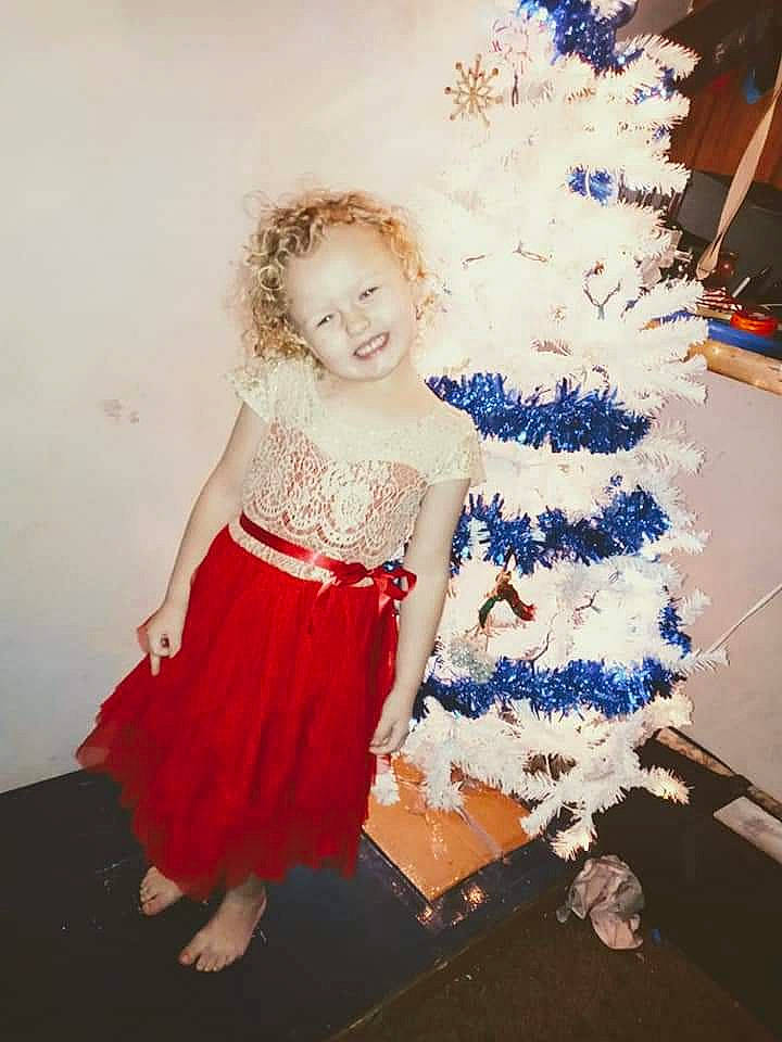 Lexa is registered to the contest to win money with this photo: baby_toddler_clothing, christmas_decoration, christmas_ornament, christmas_tree, conifer, day_dress, electric_blue, event, fashion_design, fun, happy, holiday, holiday_ornament, joy, ornament, pattern, person, smile, standing, toddler