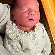 Navy joined the competition — help win amazing prizes! newborn, baby, sleeping, knit_sweater, cream_color, buttons, infant, peaceful, closeup, person, resting, soft_lighting, indoor, wood_surface, handheld, cute, portrait, child, young, warm