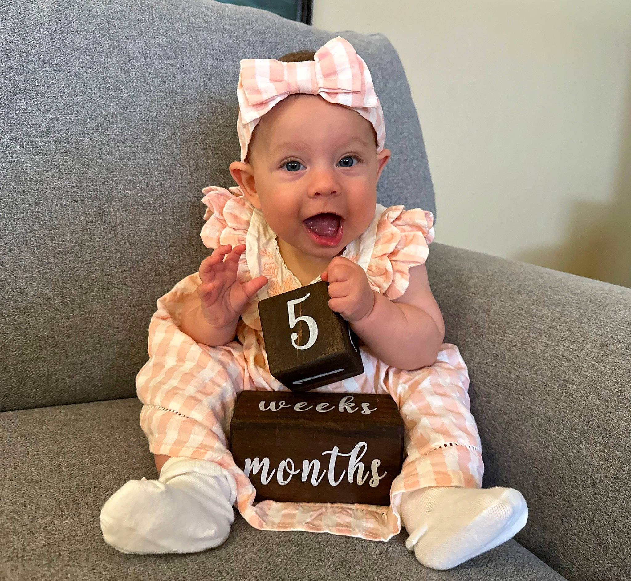 Sierra is registered to the contest to win money with this photo: baby, baby_laughing, baby_products, baby_toddler_clothing, baseball_cap, cap, cheek, child, comfort, costume_hat, fashion_accessory, foot, fun, gesture, happy, headwear, person, sitting, sleeve, smile