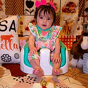Elisá is registered to the contest to win money with this photo: baby, baby_seat, birthday_cake, candle, celebration, child, colorful, cute, decorated_background, fabric, face, floral_outfit, foot, horse_toy, indoor, pillow, pink_bow, plush_toy, sitting, table