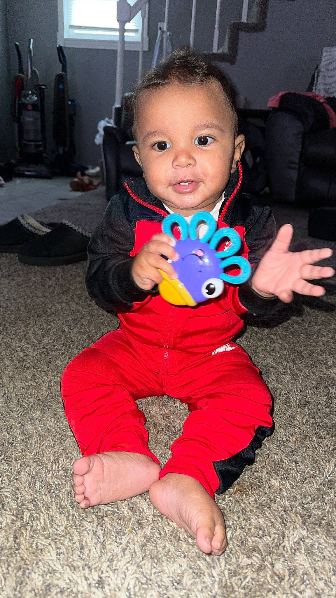 Dhall is registered to the contest to win money with this photo: baby, baby_toddler_clothing, chair, cheek, child, event, eye, face, facial_expression, finger, flooring, foot, fun, happy, head, person, play, sitting, skin, smile